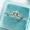 Teal sapphire ring with accent diamonds and hammered gold