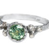 Non traditional engagement ring with green sapphire and diamonds,