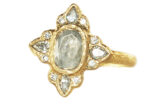 Oval raw diamond with a halo of twelve accent diamonds, hammered gold ring