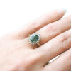 non traditional engagement ring with an oval green sapphire and diamonds, on hand