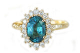 Oval teal sapphire set in a diamond halo artisanal ring