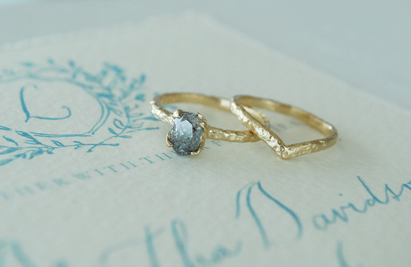 salt and pepper oval diamond engagement ring with curved wedding band, hammered gold