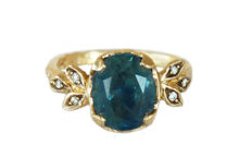 Oval teal sapphire set in gold leaves and diamonds, artisanal ring