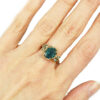 nature inspired teal sapphire ring with golden leaves and accent diamonds