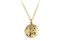 hammered gold medallion with three leaves and diamonds