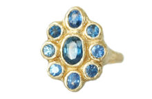 Artisanal textured gold ring with nine oval and round rustic blue sapphires, made