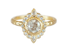 Artisanal textured gold ring with a round icy diamond and an oval halo of round and pear diamonds
