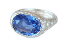 Textured white gold ring with large oval blue sapphire and accent diamonds