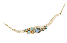 Statement neck piece with blue sapphires, aquamarines and zircons made with textured gold