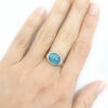 Oval aquamarine cabochon textured gold ring on hand