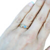Three gold leaf ring with a round blue sapphire