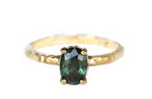 Oval deep teal sapphire ring set in prongs in hammered gold