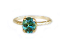 Nature inspired engagement ring design with an oval teal Australian sapphire set in golden leaf prongs
