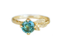 Textured gold ring with a round teal sapphire and gold leaves
