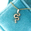 Gold serpent necklace on a velvet box