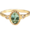 Oval green sapphire ring flanked by two accent diamonds