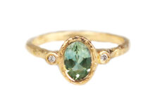 Oval green sapphire ring flanked by two accent diamonds