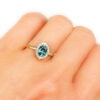 Blue oval sapphire and a halo of diamonds ring, on a hand