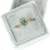 Blue oval sapphire and a halo of diamonds ring in a velvet box
