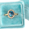 Teal sapphire ring with diamond halo, vintage style rosetta design in a velvet ring box