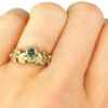Gold leaves ring with green sapphire and accent diamonds on a hand