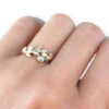 old mine cut diamond wreath ring with gold leaves on a hand