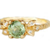 Nature inspired green sapphire ring with golden leaves and accent diamonds