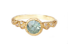 Light green sapphire ring with accent diamonds on shoulders