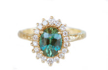 Light green-blue sapphire and diamond halo ring in a vintage rosetta style
