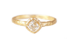 textured gold ring set with an old mine cut cushion diamond