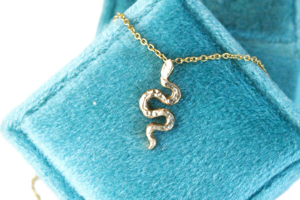 gold serpent necklace on vintage velvet box