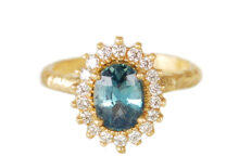 textured gold ring with an oval teal sapphire and a halo of natural diamonds