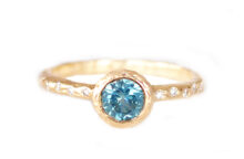 Sculpted gold engagement ring with teal sapphire and accent diamonds
