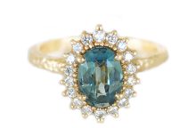 large oval teal sapphire and a halo of diamonds engagement ring